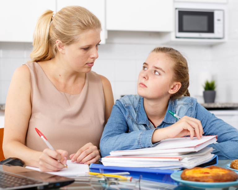 Mutter und Tochter bei Hausaufgaben am Tisch in Berlin