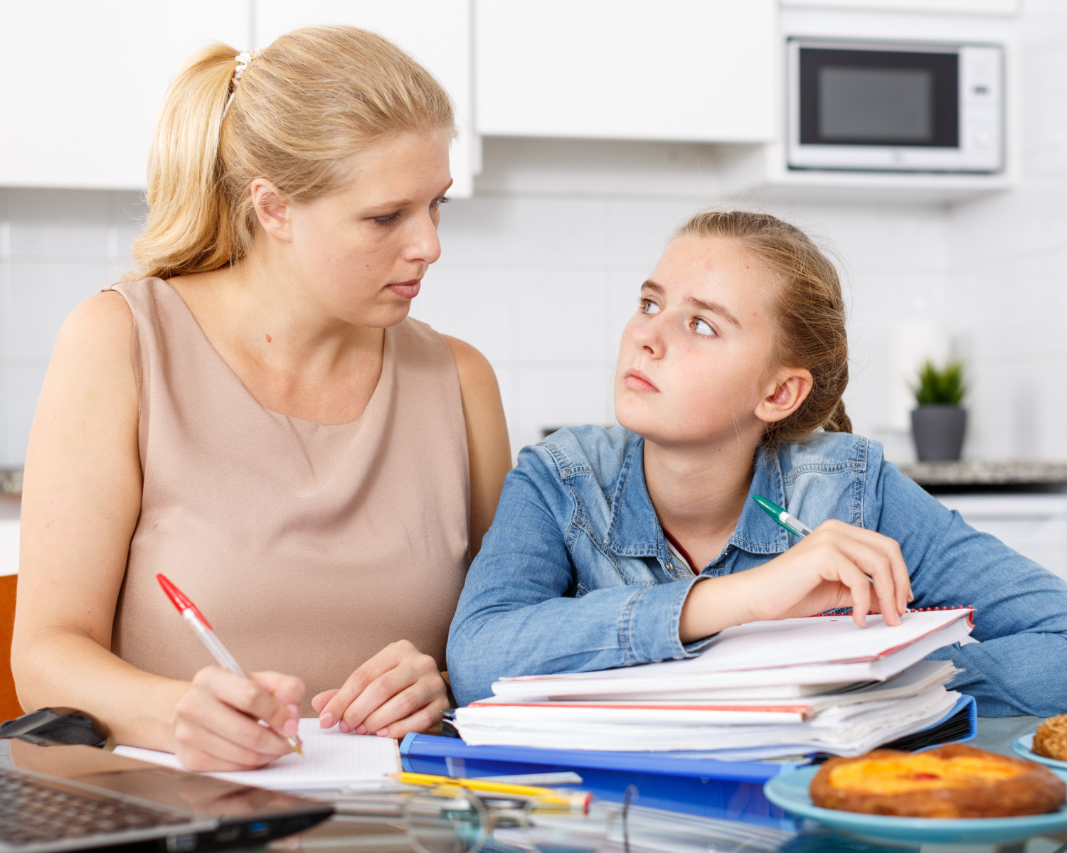 Mutter und Tochter bei Hausaufgaben am Tisch in Berlin